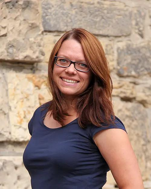 Kristina Scholz lächelt im dunkelblauen T-Shirt in die Kamera.