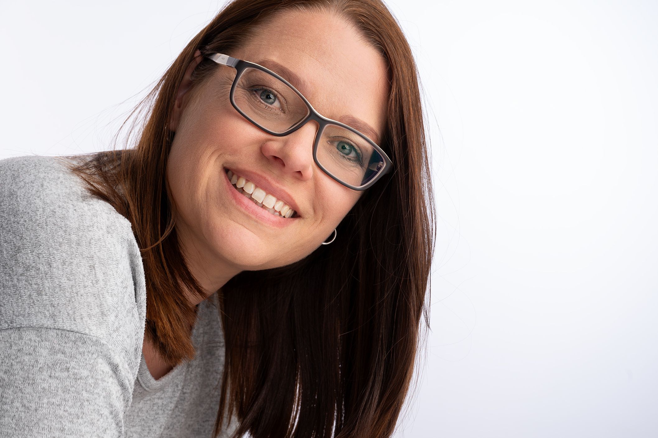 Karina Scholz bietet verschiedene Angebote als Pressestelle auf Zeit an und lächelt in einem graue Pulli in die Kamera.